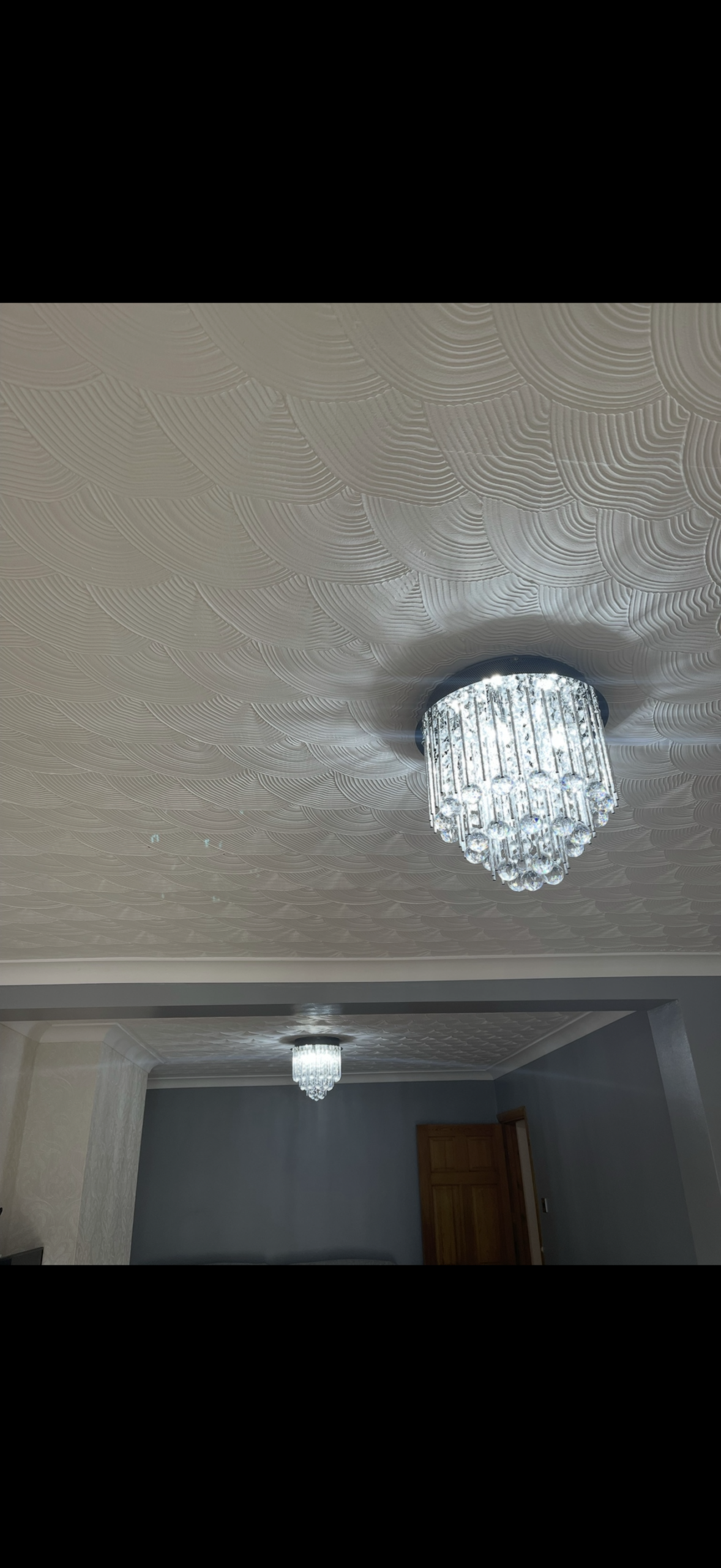 crystal-chandelier-lights-textured-swirl-ceiling